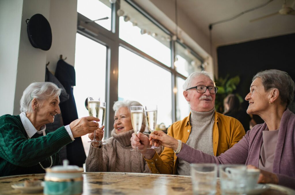 four people at a table raising glass flutes in a toast