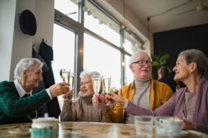 four people at a table raising glass flutes in a toast