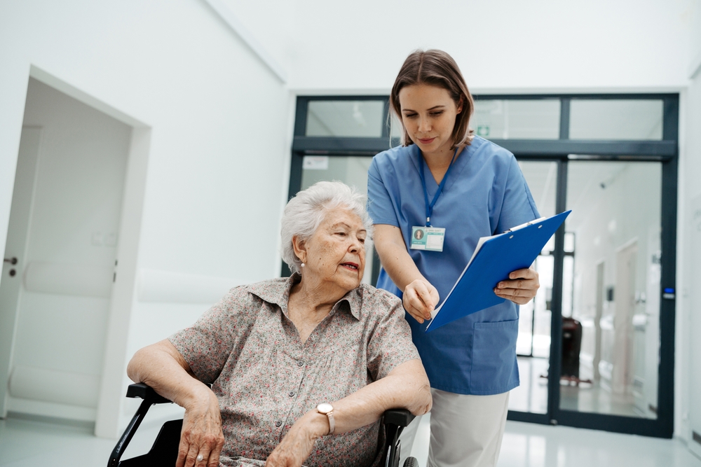 a healthcare provider is talking with a elderly patient about discharge planning at the entrance of a hallway